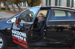 Pani Joanna w samochodzie Opel Astra z logo Narodowej Loterii Paragonowej