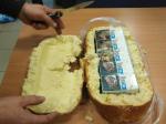 rozkrojona bułka, w środku 20 paczek papierosów