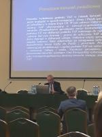 Dyrektor Izby Administracji Skarbowej w Lublinie prezentuje wykład pt. Karuzela podatkowa VAT w świetle orzecznictwa krajowego i unijnego. W tle wyświetlany jest slajd z prezentacji.