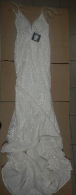 Na kartonie rozłożona suknia ślubna w kolorze ecru 