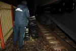 Noc. Przy wagonie stoi funkcjonariusz służby celno-skarbowej a przed nim leżą owinięte czarną folia pakiety 