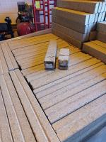 Na brykietach z trocin leży jeden rozcięty a w nim widoczne paczki z papierosami 