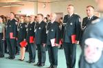 7 funkcjonariuszy celno-skarbowych w galowych mundurach stoi na baczność. W ręcę każdy z nich trzyma czerwoną teczkę.