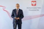 Minister Artur Soboń przy mikrofonie, w tle napis ministerstwo finansów,