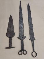 Na zdjęciu widoczne trzy starożytne żelazne miecze