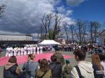 Widoczny ogólne ujęcie uczestników dnia otwartego w Janowie Podlaskim. Na placu około kilkaset osób. W tle stoiska służb mundurowych. 