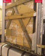 Zbliżenie na naczepę. Widoczne ustawione kartony. Jeden karton jest otwarty. W środku znajdują się papierosy.