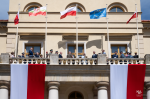 Flaga Rzeczpospolitej Polskiej, Unii Europejskiej oraz Lublina na Ratuszu Miejskim w Lublinie. Zebrani goście na balkonie Ratusza.