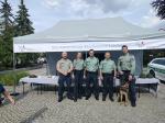 5 funkcjonariuszy SCS i pies na tle namiotu KAS