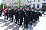 Na pierwszym planie funkcjonariusze Służby Celno-Skarbowej w mundurach służbowych stoją w szeregu z bronią.