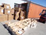 Otwarty kontener. Przed nim kilkadziesiąt kartonów. W kilku otwartych widać paczki z papierosami 