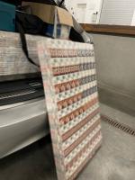 Paczki z papierosami w i przed otwartym bagaznikiem samochodu osobowego 