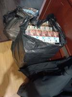 czarne foliowe worki, z których wystają paczki papierosów