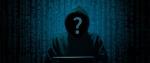 Zakapturzona osoba przy komputerze, zamiast twarzy ma znak zapytania.