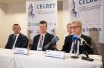 Konferencja prasowa kierownictwa grupy CELBET - do mikrofonu mówi Head of CELBET. Obok siedzi dwóch mężczyzn.